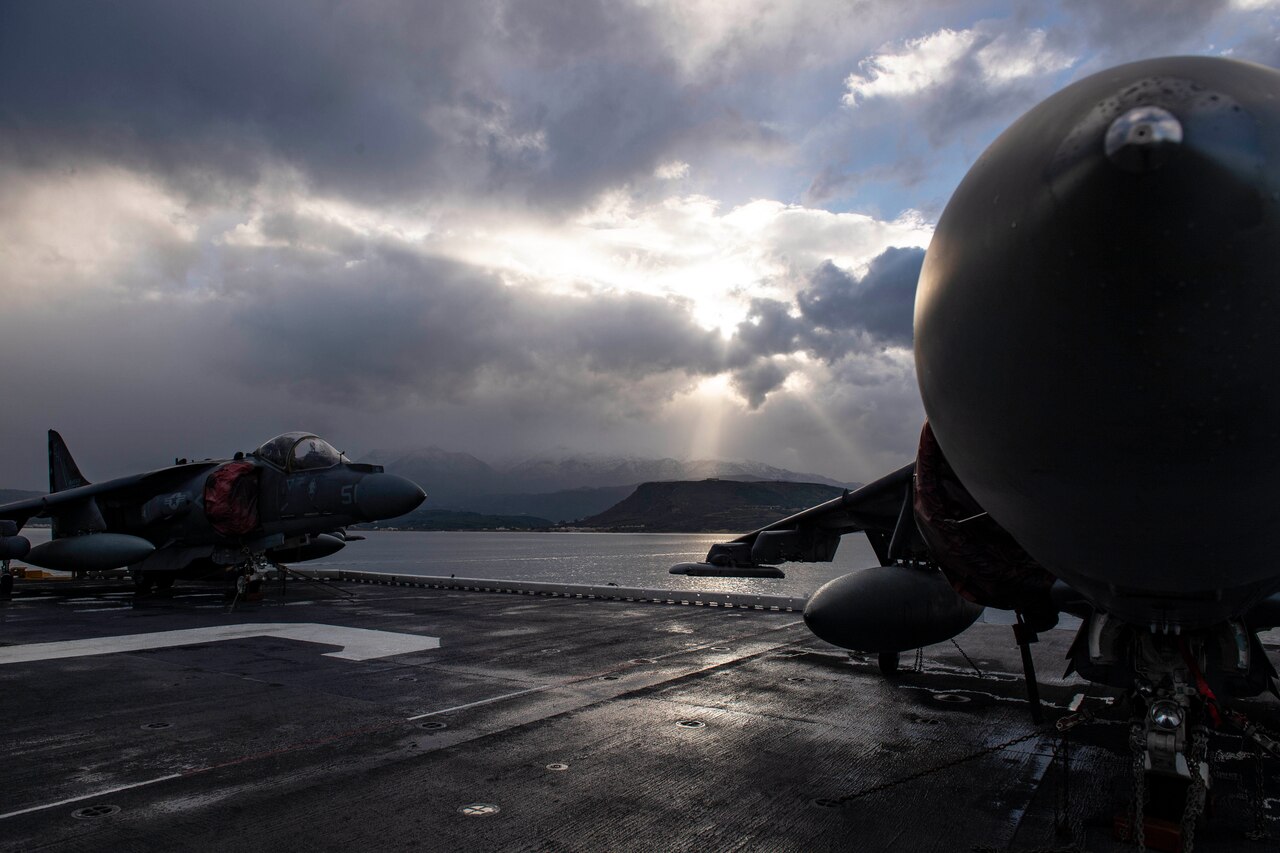 Two aircraft sit on the deck of a ship.