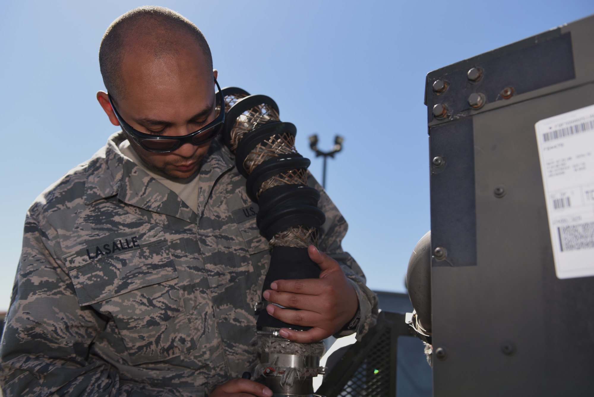 U.S. Air Force Senior Airman Ayreial Lasalle, 60th Maintenance Squadron aerospace ground equipment journeyman, plugs a pipe hose into a generator June 5, 2019, at Travis Air Force Base, California. The AGE flight ensures other maintenance teams have the equipment they need to launch aircraft on time. (U.S. Air Force photo by Airman 1st Class Cameron Otte)