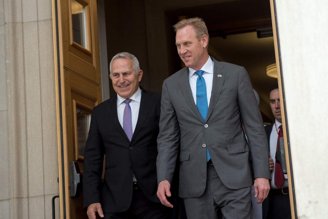 Acting Defense Secretary Patrick M. Shanahan and another man exit through doors at the Pentagon.