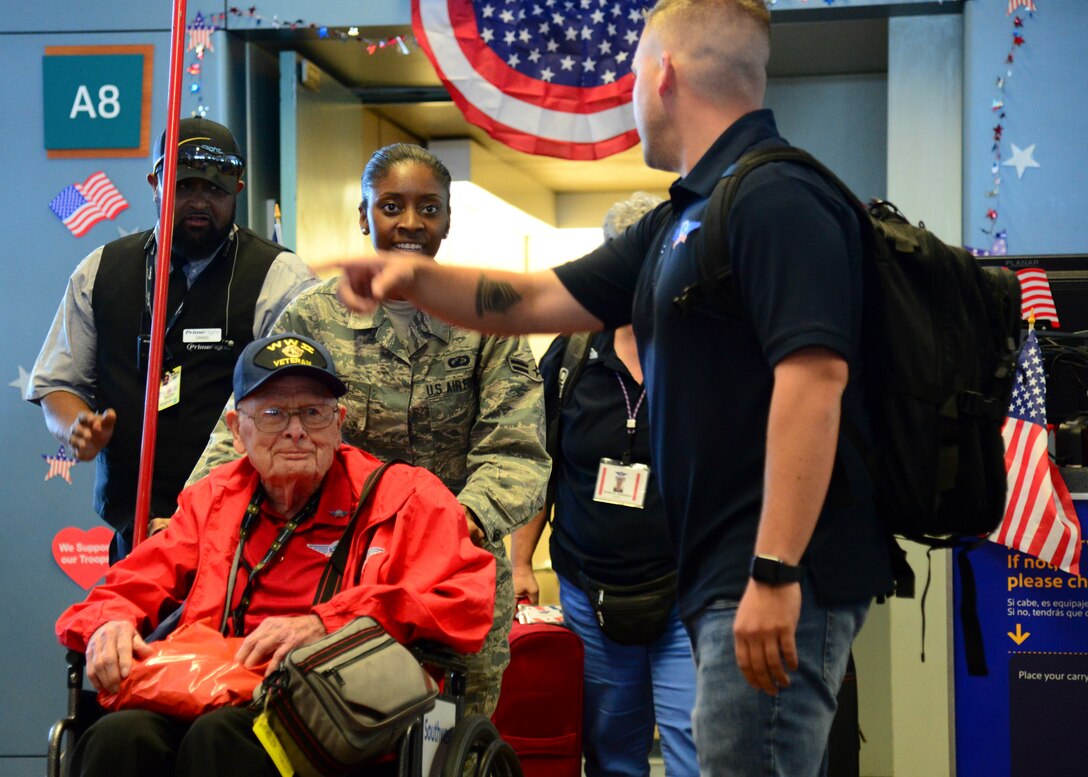 Airman First Class Cassandra Nyati, 377th Air Base Wing, escorts veteran Alfred Baye off his flight at the Sunport Airport, Albuquerque, N.M. June 7, 2019. Kirtland Airmen volunteered to assist with the three-day mission known as an Honor Flight, a mission conducted by non-profit organizations dedicated to transporting as many United States military veterans as possible to see the memorials of the respective war they fought in Washington, D.C. (U.S. Air Force photo by Jessie Perkins)