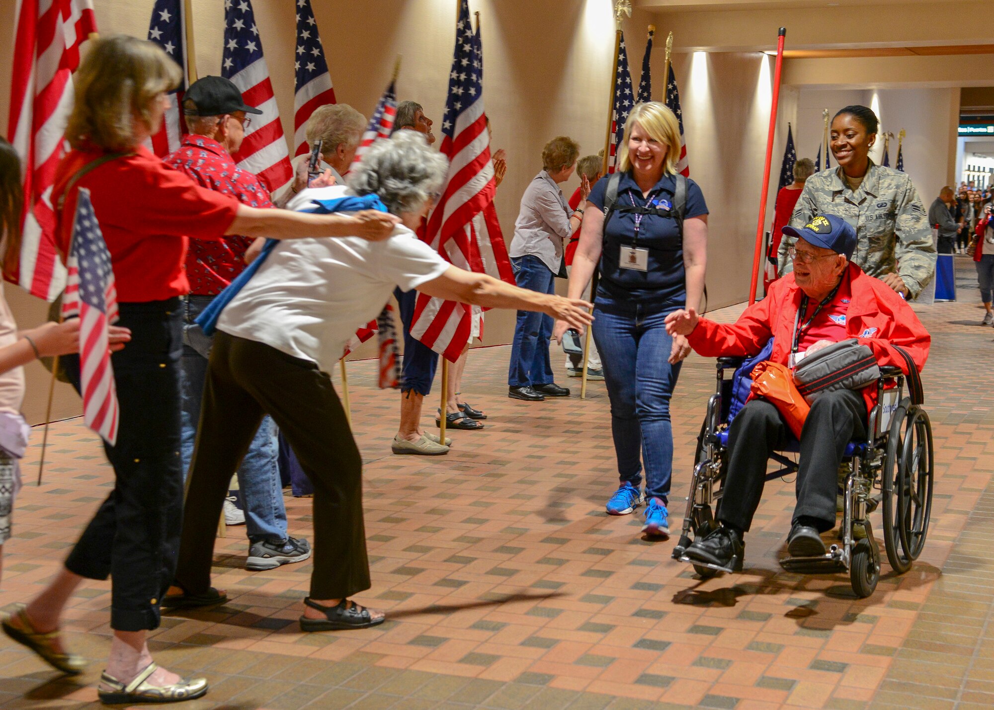 Airman First Class Cassandra Nyati, 377th Air Base Wing, escorts veteran Alfred Baye off his flight at the Sunport Airport, Albuquerque, N.M. June 7, 2019. Kirtland Airmen volunteered to assist with the three-day mission known as an Honor Flight, a mission conducted by non-profit organizations dedicated to transporting as many United States military veterans as possible to see the memorials of the respective war they fought in Washington, D.C. (U.S. Air Force photo by Jessie Perkins)