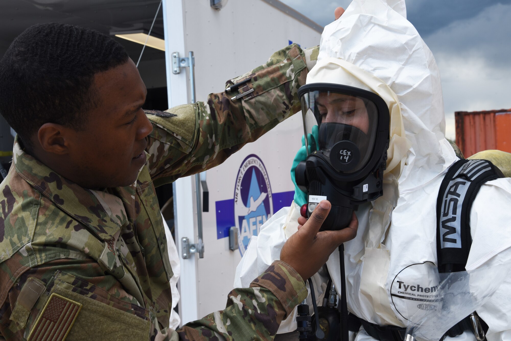 U.S. Air Force Staff Sgt. Aaron Stubbs, 90th Civil Engineer Squadron NCO in charge of emergency management, activates the air supply for Senior Airman Sierra McKenna, 90th CES emergency management technician, during a training exercise at F.E. Warren Air Force Base, Wyoming, June 7, 2019. Emergency management personnel must know how to properly use a self-contained breathing apparatus for real-world scenarios. (U.S. Air Force photo by Senior Airman Breanna Carter)