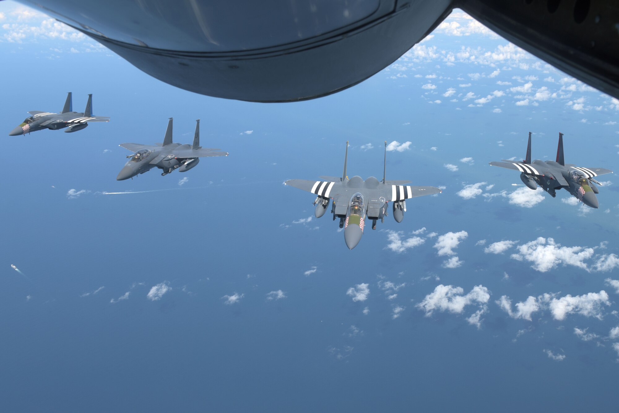 Four U.S. Air Force F-15s, assigned to the 48th Fighter Squadron at RAF Lakenheath, England, fly in formation behind a U.S. Air Force KC-135 Stratotanker off the Southern coast of England, June 6, 2019. The F15s were part of a commemorative 75th anniversary D-Day flyover in France. D-Day reflects the strength of enduring relationships and proven partnerships. This historic relationship has allowed U.S. forces to remain ready and have the strategic access in Europe to accomplish high-priority missions with our European allies and partners. (U.S. Air Force photo by Senior Airman Benjamin Cooper)