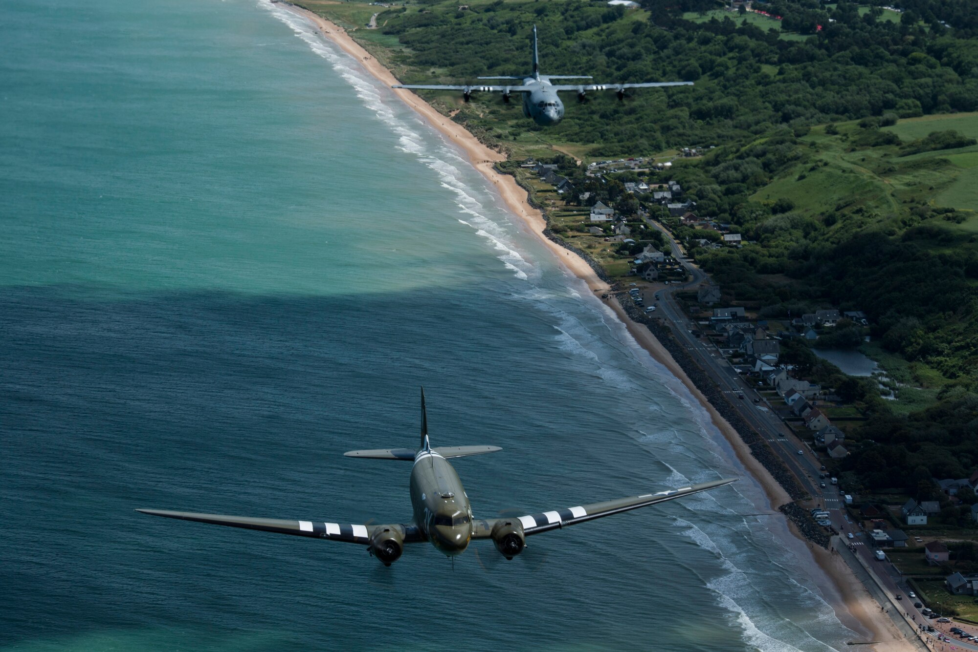 A Douglas C-47 Dakota, nicknamed “That’s All Brother”, flies with a U.S. Air Force C-130J Super Hercules, assigned to the 37th Airlift Squadron, Ramstein Air Base, Germany, over Normandy, France, June 8, 2019. The C-130J wore invasion markings, similar to it’s legacy squadron, the 37th Troop Carrier Squadron, who flew combat missions during Operation Neptune, June 6, 1944. (U.S. Air Force photo by Senior Airman Devin M. Rumbaugh)