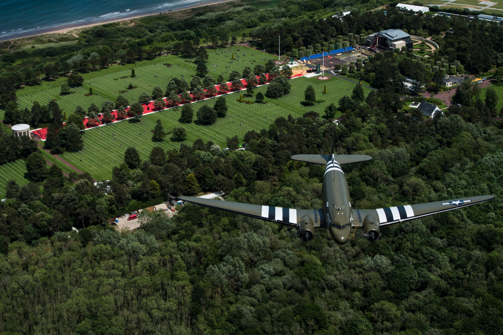 A Douglas C-47 Dakota, nicknamed “That’s All Brother”, flies over the Normandy American Cemetery and Memorial in Colleville-sur-Mer, France, June 8, 2019. “That’s All Brother” flew combat missions during Operation Neptune June 6, 1944. The C-47 conducted an interfly mission with a U.S. Air Force C-130J Super Hercules wearing identical invasion markings. (U.S. Air Force photo by Senior Airman Devin M. Rumbaugh)