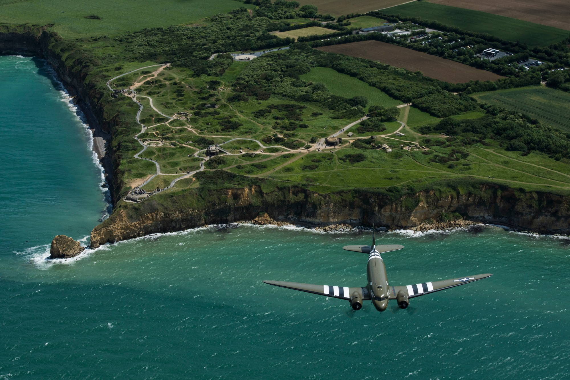 A Douglas C-47 Dakota, nicknamed “That’s All Brother”, flies with a U.S. Air Force C-130J Super Hercules, assigned to the 37th Airlift Squadron, Ramstein Air Base, Germany, over Pointe-du-Hoc, France, June 8, 2019. “That’s All Brother” flew operations during the invasion of Normandy. (U.S. Air Force photo by Senior Airman Devin M. Rumbaugh)