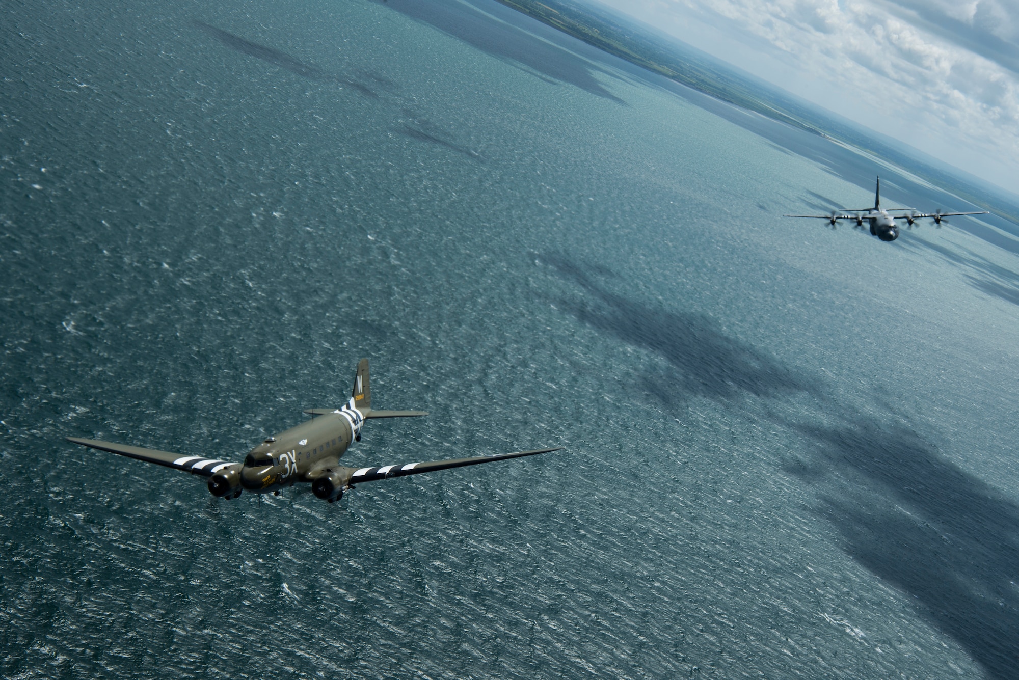 A Douglas C-47 Dakota, nicknamed “That’s All Brother”, flies with a U.S. Air Force C-130J Super Hercules, assigned to the 37th Airlift Squadron, Ramstein Air Base, Germany, over the English Channel, June 8, 2019. The 37th Troop Carrier Squadron, the legacy squadron to the 37th AS, wore the “W7” or “Whiskey 7” markings during Operation Neptune, June 6, 1944. “That’s All Brother” flew operations during the invasion of Normandy. (U.S. Air Force photo by Senior Airman Devin M. Rumbaugh)