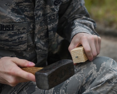 Airman 1st Class Weston Foust, an engineering assistant from the 20th Civil Engineer Squadron at Shaw Air Force Base, S.C., hammers a nail into a stake while setting up global positioning receiver, June 5, 2019 at North Auxiliary Airfield, S.C. during an aircraft crash analysis exercise. Joint Base Charleston engineering assistants were joined by their counterparts from Shaw Air Force Base to help younger Airmen learn what it’s like to coordinate with other bases during a real world crisis scenario. Air Force engineering assistants have the role of plotting out the positions of all debris pieces using global positioning devices during crash analysis operations. Engineering assistants specialize in planning and managing construction projects for bases and ensuring that facilities and structures are able to operate at full capacity.