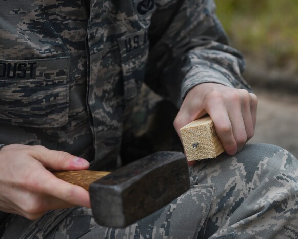 Airman 1st Class Weston Foust, an engineering assistant from the 20th Civil Engineer Squadron at Shaw Air Force Base, S.C., hammers a nail into a stake while setting up global positioning receiver, June 5, 2019 at North Auxiliary Airfield, S.C. during an aircraft crash analysis exercise. Joint Base Charleston engineering assistants were joined by their counterparts from Shaw Air Force Base to help younger Airmen learn what it’s like to coordinate with other bases during a real world crisis scenario. Air Force engineering assistants have the role of plotting out the positions of all debris pieces using global positioning devices during crash analysis operations. Engineering assistants specialize in planning and managing construction projects for bases and ensuring that facilities and structures are able to operate at full capacity.