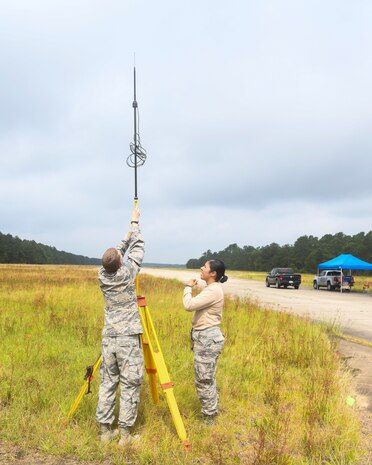 Airmen 1st Class Weston Foust and Krystal Figueroa, engineering assistants from the 20th Civil Engineer Squadron at Shaw Air Force Base, S.C., set up a global positioning device, June 5, 2019 at North Auxiliary Airfield, S.C., during an aircraft crash analysis exercise. The exercise allowed for Airmen to enhance their readiness and job knowledge by simulating an on-scene aircraft crash with real world requirements and standards. Air Force engineering assistants have the role of plotting out the positions of all debris pieces using global positioning devices during crash analysis operations. Engineering assistants specialize in planning and managing construction projects for military bases and ensuring that facilities and structures are able to operate at full capacity.