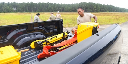 Airman 1st Class Miguel Alano, an engineering assistant from the 628th Civil Engineer Squadron, S.C., loads equipment into a truck after an aircraft crash analysis exercise June 5, 2019, at North Auxiliary Airfield, S.C. The exercise featured a simulated aircraft crash and required engineering assistants to plot the positions of simulated debris. Joint Base Charleston engineering assistants were joined by their counterparts from Shaw Air Force Base, S.C., to help younger Airmen learn what it’s like to coordinate with other bases during a real world crisis scenario. Air Force engineering assistants have the role of plotting out the positions of all debris pieces using global positioning devices during crash analysis operations. Engineering assistants specialize in planning and managing construction projects for military installations and ensuring that facilities and structures are able to operate at full capacity.