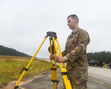 U.S. Air Force Staff Sgt. Kennith Hopkins, an engineering assistant from the 20th Civil Engineer Squadron at Shaw Air Force Base, S.C., sets up a tripod during an aircraft crash analysis exercise June 5, 2019, at North Auxiliary Airfield, S.C. Joint Base Charleston engineering assistants were joined by their counterparts from Shaw Air Force Base to help younger Airmen learn what it’s like to coordinate with other bases during a real world crisis scenario. Air Force engineering assistants have the role of plotting out the positions of all debris pieces using global positioning devices during crash analysis operations. Engineering assistants specialize in planning and managing construction projects for military installations and ensuring that facilities and structures are able to operate at full capacity. (U.S. Air Force photo by Senior Airman Cody R. Miller)