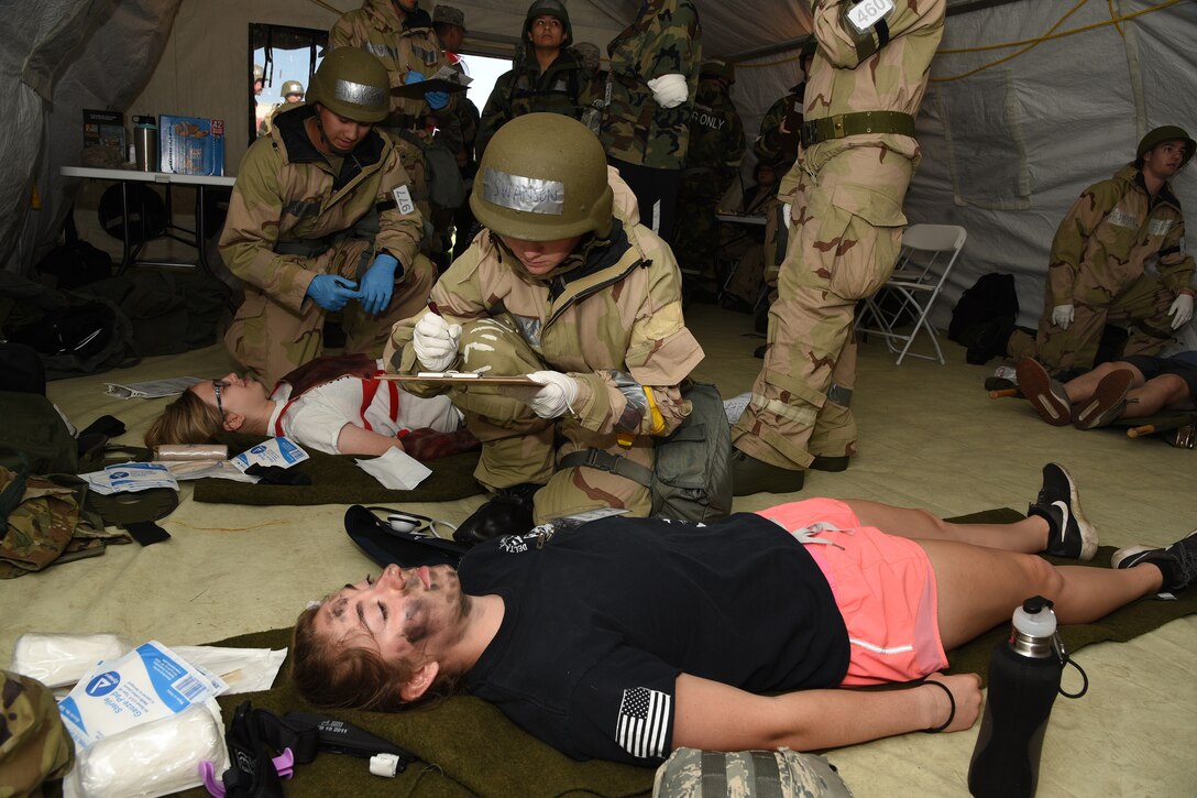 Senior Airman Abigail Swanson, of the 119th Medical Group, administers medical treatment to an Airman who is acting as an attack victim during a training exercise at the North Dakota Air National Guard Base, Fargo, N.D., June 8, 2019.