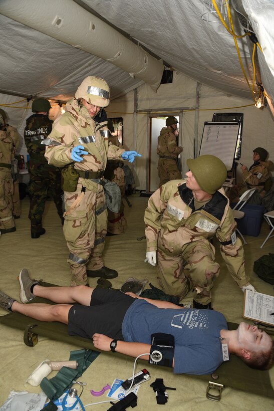 Lt. Col. Joseph Wyatt, the chief of aerospace medicine in the 119th Medical Group, gives instructions to Senior Airman Austin Hansen, evaluate a training exercise patient for treatment after a simulated enemy attack during an exercise at the North Dakota Air National Guard Base, Fargo, N.D., June 8, 2019.