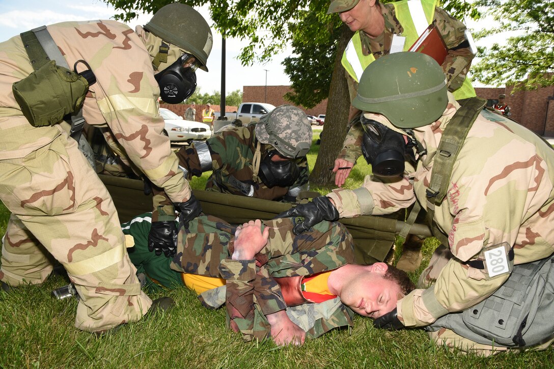 Staff Sgt. Cindy Olsen, of the 119th Force Support Squadron, center, is among a group administering self-aid and buddy care medical treatment to an Airman who is acting as an attack victim during a training exercise at the North Dakota Air National Guard Base, Fargo, N.D., June 8, 2019.