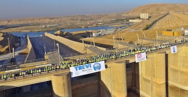 The men and women of the Mosul Dam Task Force stand on the top of the Mosul Dam spillway.  The Mosul Dam Project was a 3-year partnership started in 2016 as a joint venture among the Iraq Ministry of Water Resources, the U.S. Army Corps of Engineers, and Italian Company Trevi S.p.A. in an effort to stabilize and repair the dam, and update the infrastructure of the dam.The dam sits in a valley along the Tigris River approximately 30 miles outside Mosul City in Iraq. It is the largest dam in Iraq, and the fourth largest in the Middle East, and supplies water, hydropower, irrigation and flood control to the region.