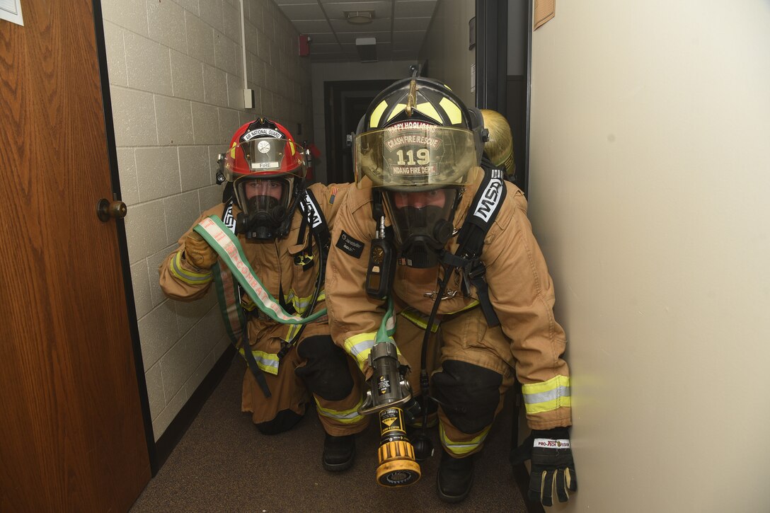 Airman 1st Class Nathan Kankelfitz leads Staff Sgt. Garrett Rixs, both fire fighters in the 119th Civil Engineer Squadron, as they conduct a search for victims through a smoky hallway following a simulated enemy attack during a training exercise at the North Dakota Air National Guard Base, Fargo, N.D., June 8, 2019.