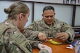 Master at Arms 1st Class Roberto Aguilar, right, kennelmaster, Area Support Group-Qatar, practices suturing while Army Sgt. Kristie Johnson, supply sergeant, 354th Medical Company (Logistics), assists during training provided by the 719th Medical Detachment Veterinary Service Support, May 31, 2019, at Camp As Sayliyah, Qatar. The training was designed to help medics and military working dog handlers provide better care immediately following an injury to one of the animals.