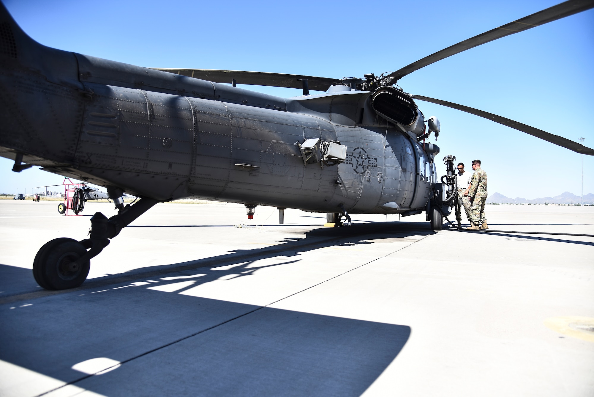 An instructor and student, assigned to the 372d Training Squadron, Detachment 11, examine a HH-60G Pavehawk weapons system at Davis-Monthan Air Force Base, Ariz., June 4, 2019. The 372d TRS, Det. 11, consists of 42 instructors responsible for training up to thousands of Airmen a year on different kinds of aircraft maintenance. (U.S. Air Force photo by Senior Airman Mya M. Crosby)