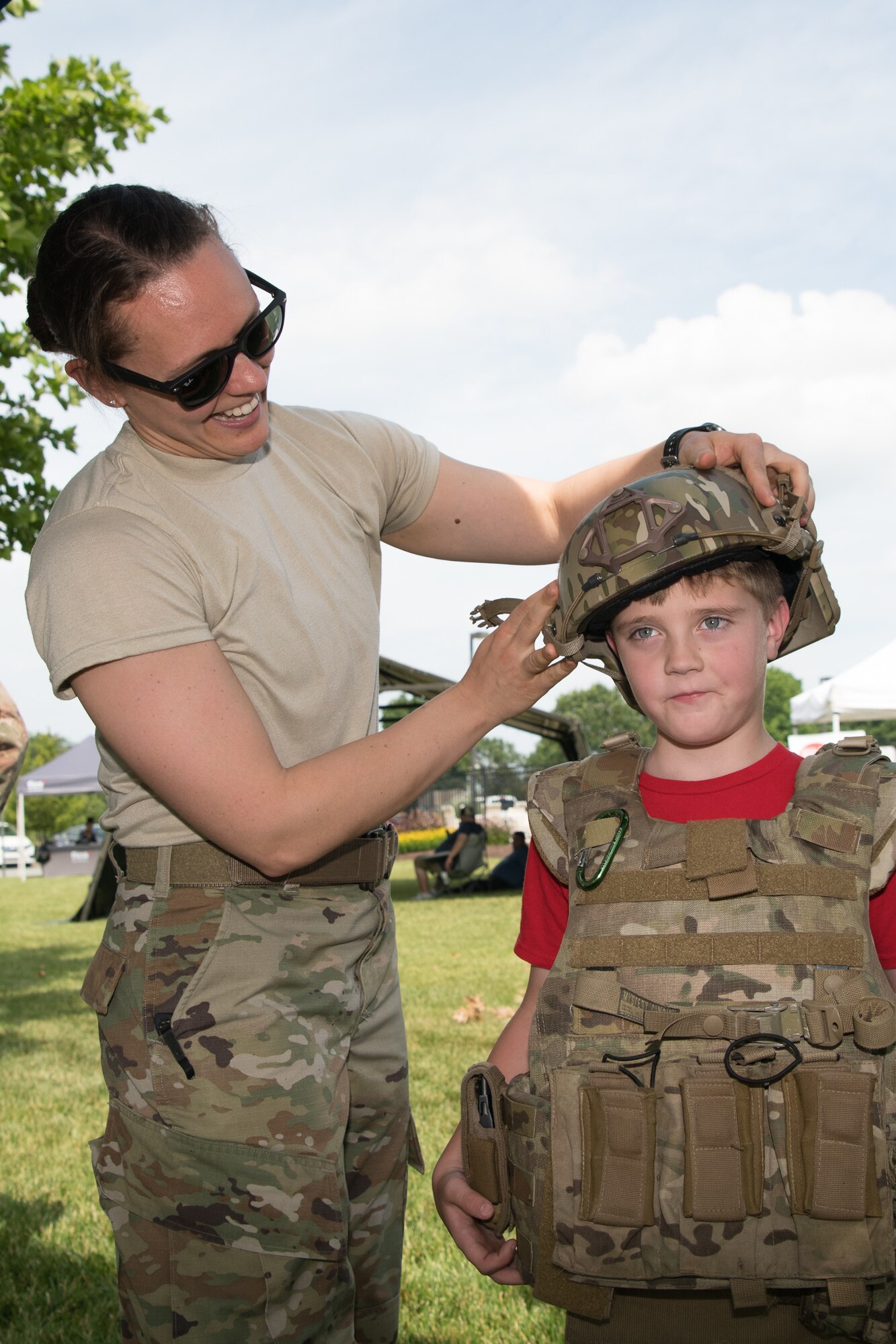 Capt. Michelle Petry, 436th Civil Engineer Squadron Explosive Ordnance Disposal flight commander helps Jasper Viktoro don a Kevlar helmet and vest at the Hurricane Block Party June 6, 2019, at the Eagle Heights family housing on Dover Air Force Base, Del. The EOD flight set up a static display to showcase the equipment they use on a regular basis. (U.S. Air Force Photo by Mauricio Campino)