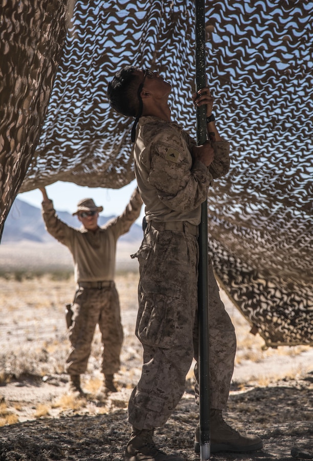 U.S. Marine Lance Cpl. Rudy Batz, a driver with 4th Assault Amphibian Battalion, 4th Marine Division sets up camouflage netting on Range 110 during Integrated Training Exercise 4-19 at Marine Corps Air Ground Combat Center Twentynine Palms, Calif., June 7, 2019. Exercises like ITX ensure Marine Forces Reserve is a proficient force, ready for world-wide deployment at any given time. (U.S. Marine Corps photo by Cpl. Tessa D. Watts)