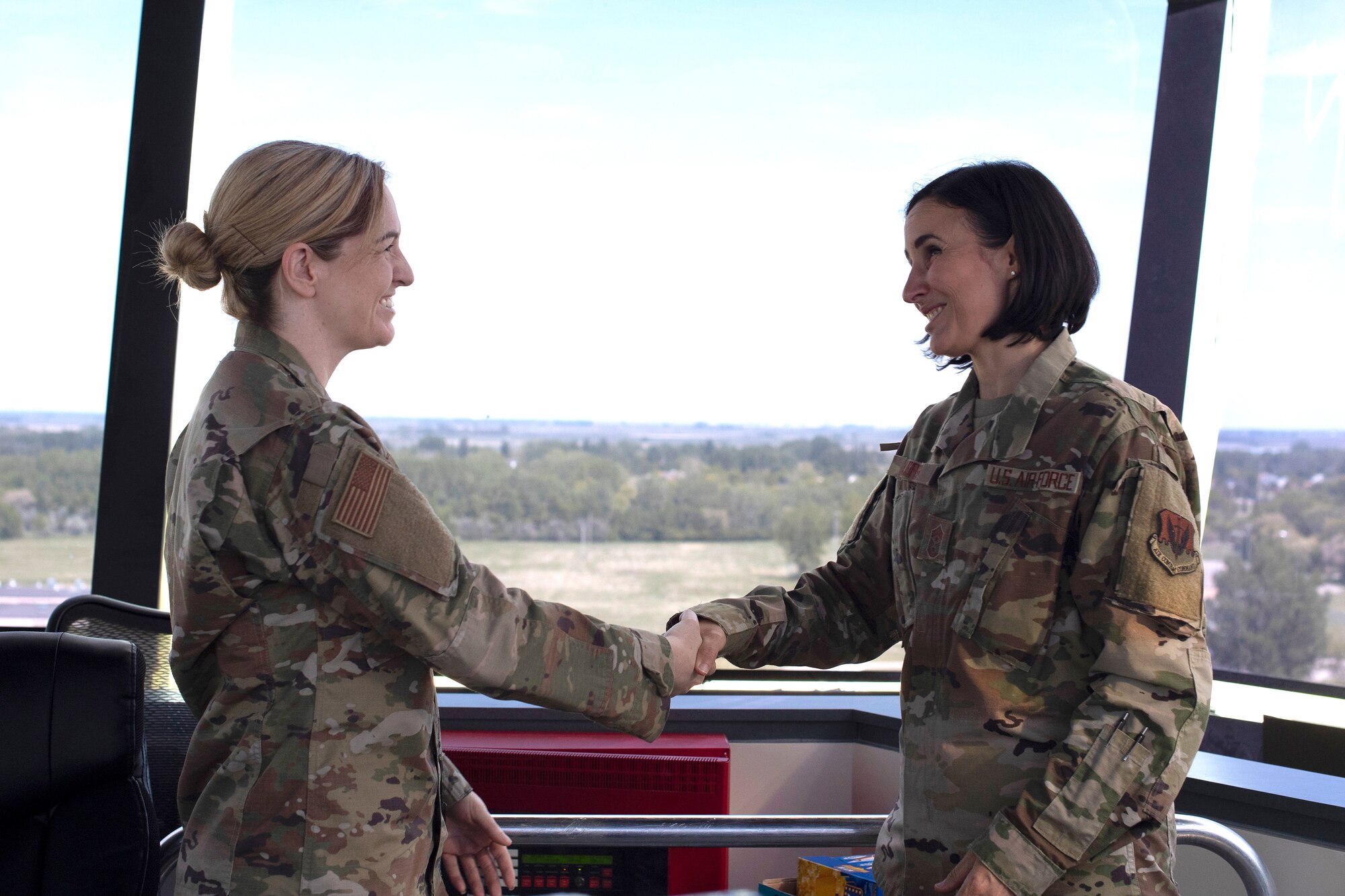 Chief Master Sgt. Summer Leifer, 25th Air Force command chief, right, coins Master Sgt. Nicole Hall, 319 OSS air traffic control senior watch supervisor, June 5, 2019, on Grand Forks Air Force Base, North Dakota. Leifer coined Hall for her quick reaction following a power outage experienced in the tower months prior. (U.S. Air Force photo by Senior Airman Elora J. Martinez)