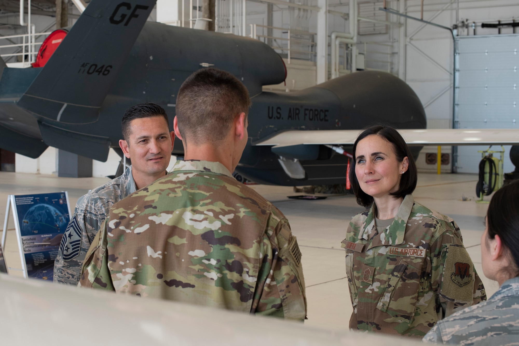 Chief Master Sgt. Summer Leifer, 25th Air Force command chief, right, receives a brief from Senior Airman Cyrus Argo, 69th Maintenance Squadron crew chief, about his role in RQ-4 Global Hawk operations June 5, 2019, on Grand Forks Air Force Base, North Dakota. Cyrus briefed alongside a sensor operator, pilot and avionics specialist to provide Leifer a complete breakdown of Grand Forks AFB’s part in the intelligence, surveillance and reconnaissance mission. (U.S. Air Force photo by Senior Airman Elora J. Martinez)