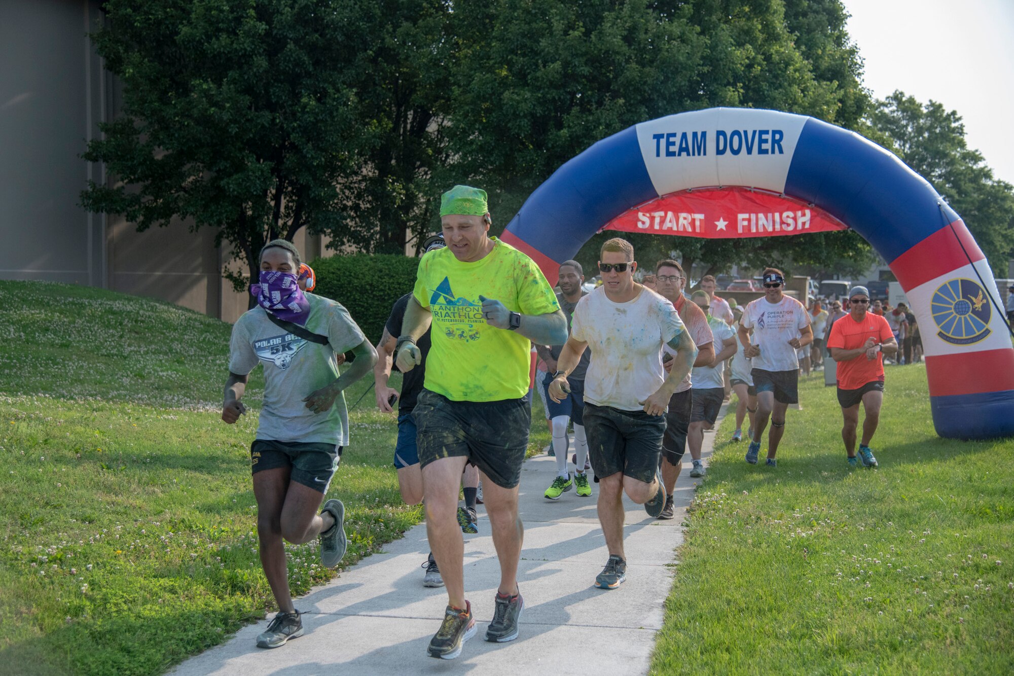 Chief Master Sgt. Anthony Green, 436th Airlift Wing command chief, leads runners across the starting line at the 2019 Sexual Assault Prevention and Response Color Run June 5, 2019, at Dover Air Force Base, Del. The run is normally held in April but was postponed due to bad weather. (U.S. Air Force photo by Staff Sgt. Esteban Esquivel)