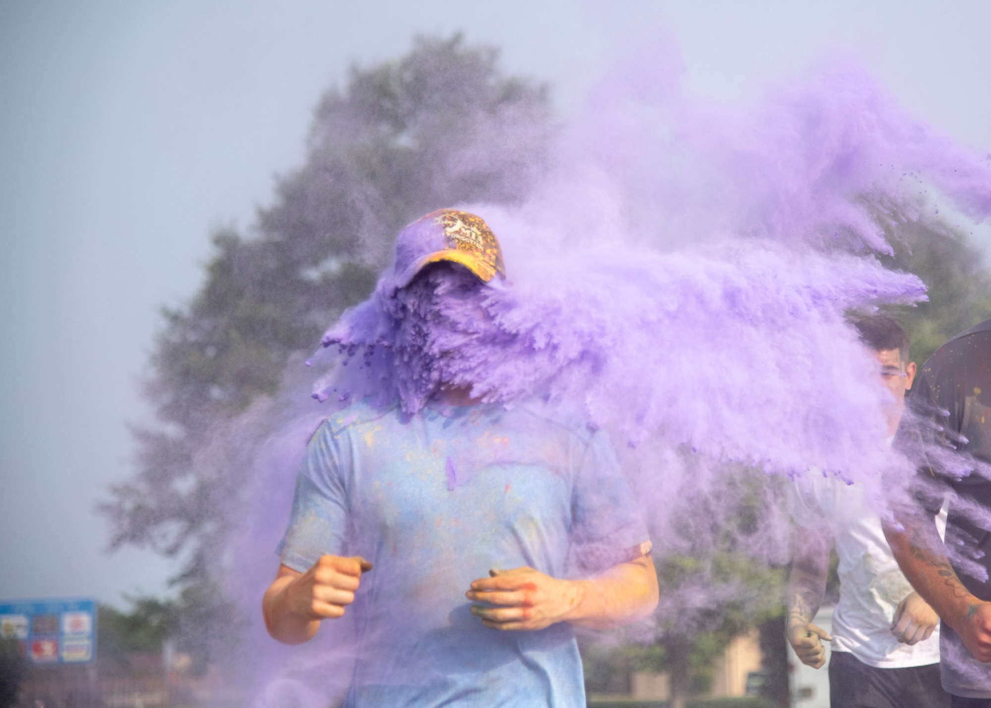 Volunteers throw purple color powder at runners during the 2019 Sexual Assault Prevention and Response Color Run June 5, 2019, at Dover Air Force Base, Del. The mixture of cornstarch, baking soda and dyes is safe and environmentally friendly. (U.S. Air Force photo by Staff Sgt. Esteban Esquivel)