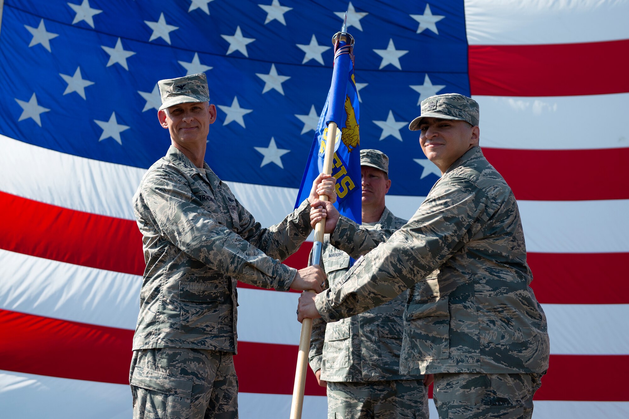 U.S. Air Force Col. James Trachier, 38th Cyberspace Engineering Installation Group commander, passes the guidon to Lt. Col. Nelson Caraballo, 85th Engineering Installation Squadron commander, during a change of command ceremony outside Maltby Hall on Keesler Air Force Base, Mississippi, June 4, 2019. The ceremony is a symbol of command being exchanged from one commander to the next. "I look forward to caring for and leading the Airmen of the 85th EIS while we deploy worldwide to engineer and install world-class capabilities," said Caraballo. (U.S. Air Force photo by Airman 1st Class Kimberly L. Mueller)
