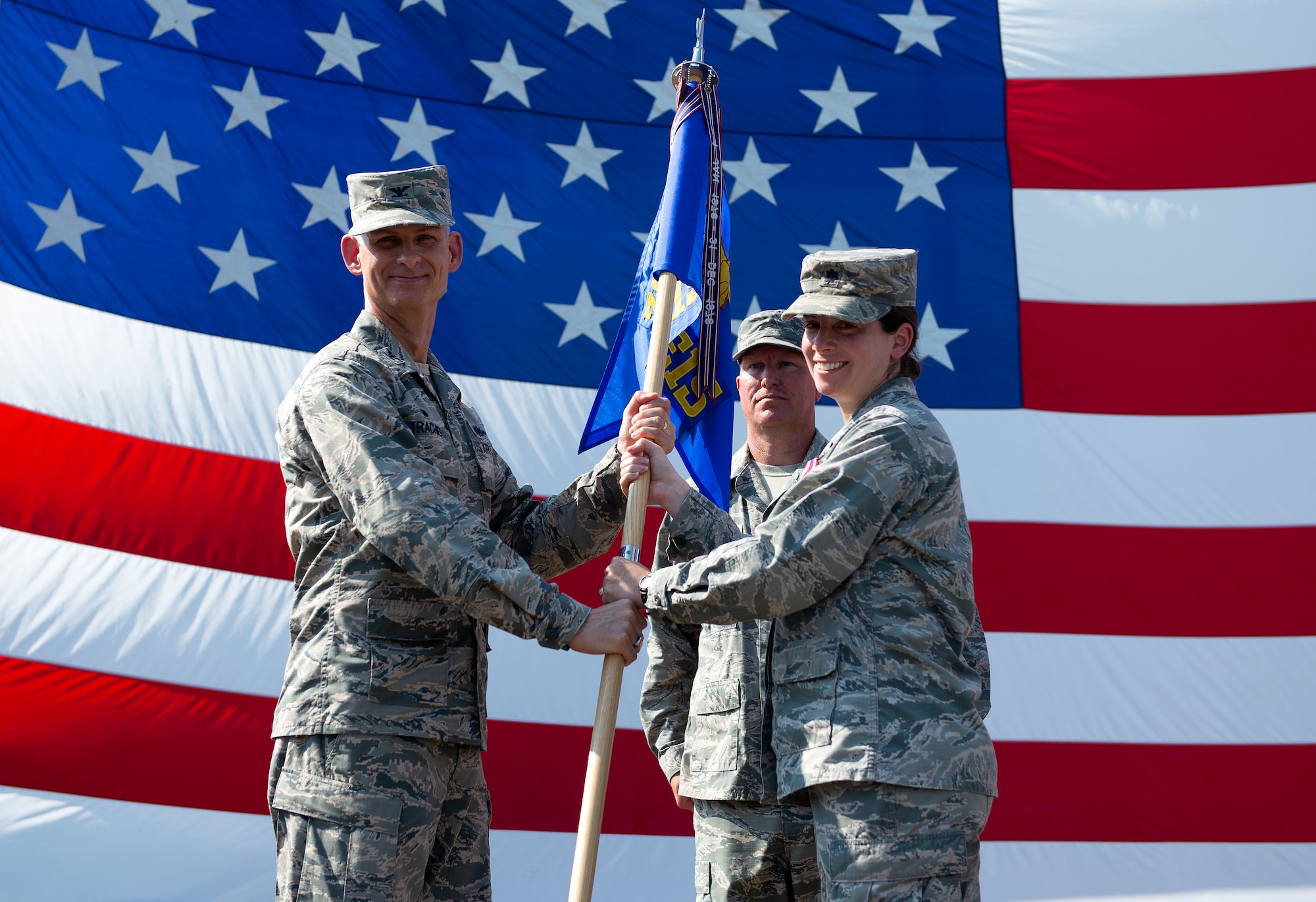 U.S. Air Force Col. James Trachier, 38th Cyberspace Engineering Installation Group commander, passes the guidon to Lt. Col. Jennifer Carns, 85th Engineering Installation Squadron outgoing commander, during a change of command ceremony outside Maltby Hall on Keesler Air Force Base, Mississippi, June 4, 2019. The ceremony is a symbol of command being exchanged from one commander to the next. (U.S. Air Force photo by Airman 1st Class Kimberly L. Mueller)