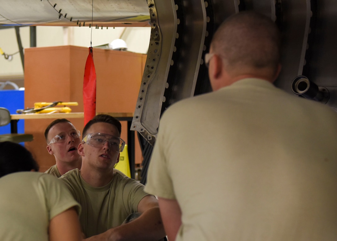 Airman 1st Class Daniel Hawkins (center), 361st Training Squadron aerospace propulsion apprentice, discusses the various engine components of a McDonnell Douglas F-15 Eagle with Staff Sgt. Matthew Hansen (right), 361st Training Squadron aerospace ground propulsion instructor, at Sheppard Air Force Base, Texas, Jun. 10, 2019. Hawkins, an ACE award recipient, received a score of 100% on all of his progress checks and block tests during his training course. Hawkins enjoys the challenges that along come with his job. (U.S. Air Force photo by Senior Airman Ilyana A. Escalona)