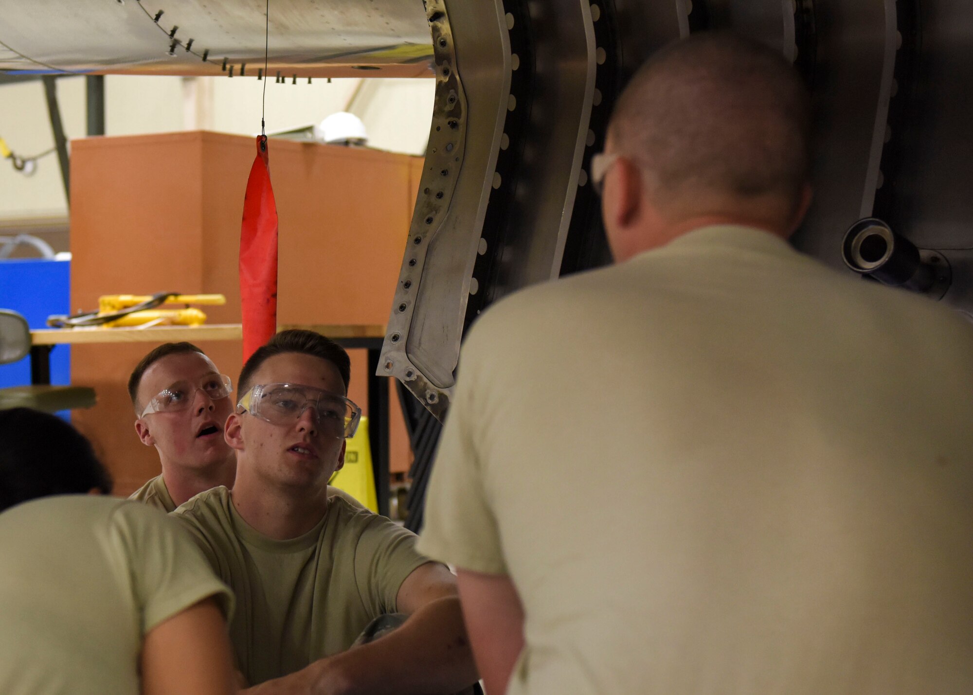 Airman 1st Class Daniel Hawkins (center), 361st Training Squadron aerospace propulsion apprentice, discusses the various engine components of a McDonnell Douglas F-15 Eagle with Staff Sgt. Matthew Hansen (right), 361st Training Squadron aerospace ground propulsion instructor, at Sheppard Air Force Base, Texas, Jun. 10, 2019. Hawkins, an ACE award recipient, received a score of 100% on all of his progress checks and block tests during his training course. Hawkins enjoys the challenges that along come with his job. (U.S. Air Force photo by Senior Airman Ilyana A. Escalona)