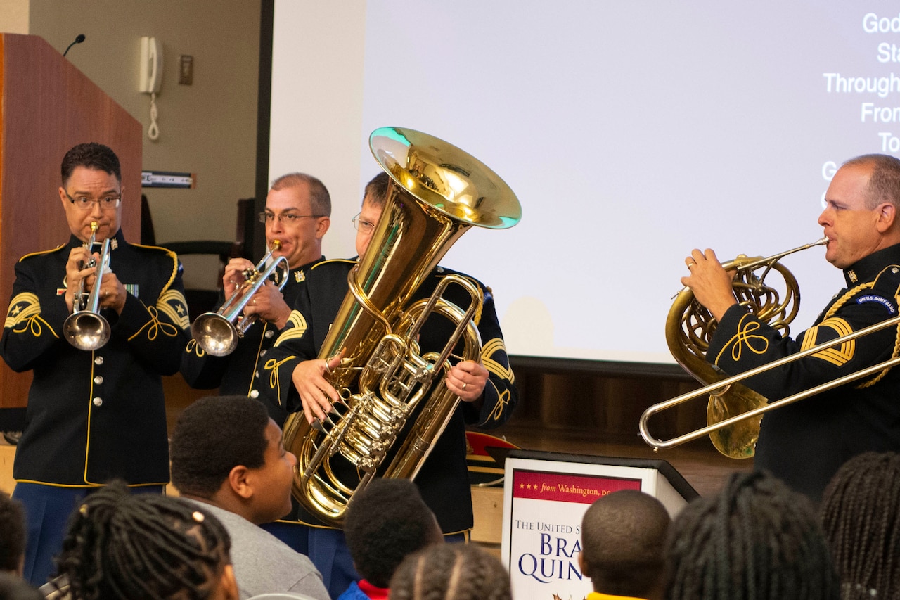 A military brass band plays for an audience of kids.