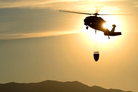 Members of the Utah Army National Guard 2-211 Aviation Battalion assist in fighting fires in northern Utah Aug. 12, 2013. The National Guard UH-60 Blackhawk dropped more than 8,500 gallons of water in one day on two separate fires in northern Utah. (U.S. Air Force photo\ Tim Chacon)