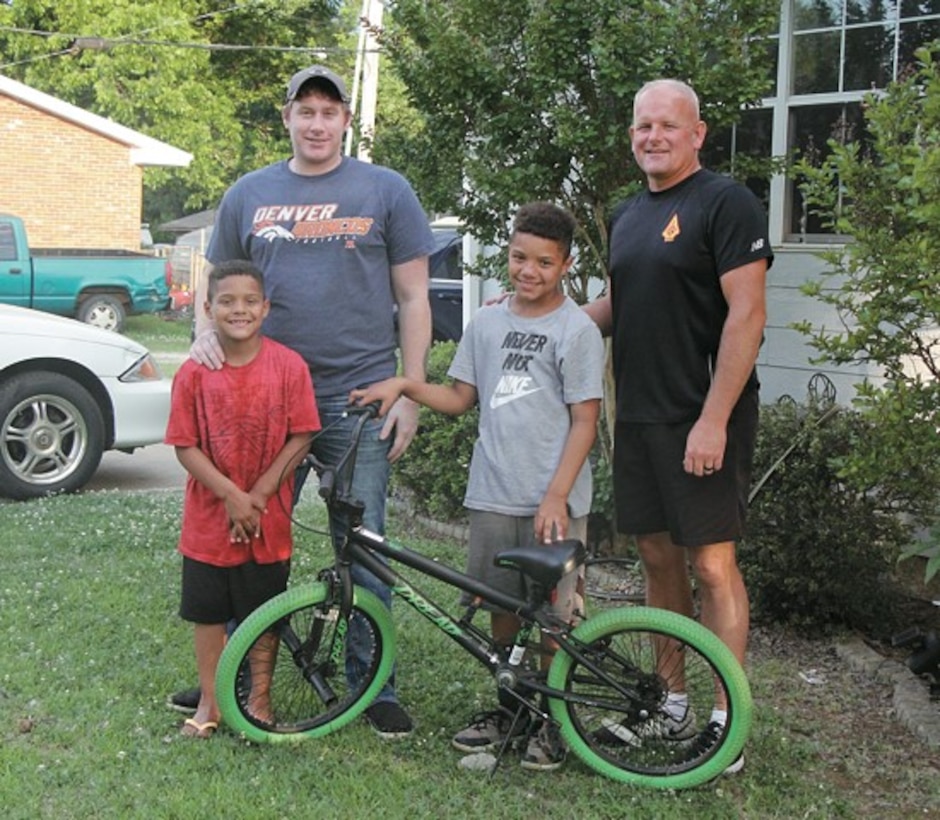 Torren Jackson (center) is pictured with rescuers that helped free him from swift running water May 29, 2019 when he was swept from the road while riding his bike and trapped inside a culvert in Prague, Oklahoma. From left: Teggan Jackson, Dakota Fite, Torren Jackson and Eric Whitesel. (Courtesy photo by Sharon Lee/Prague Times Herald)