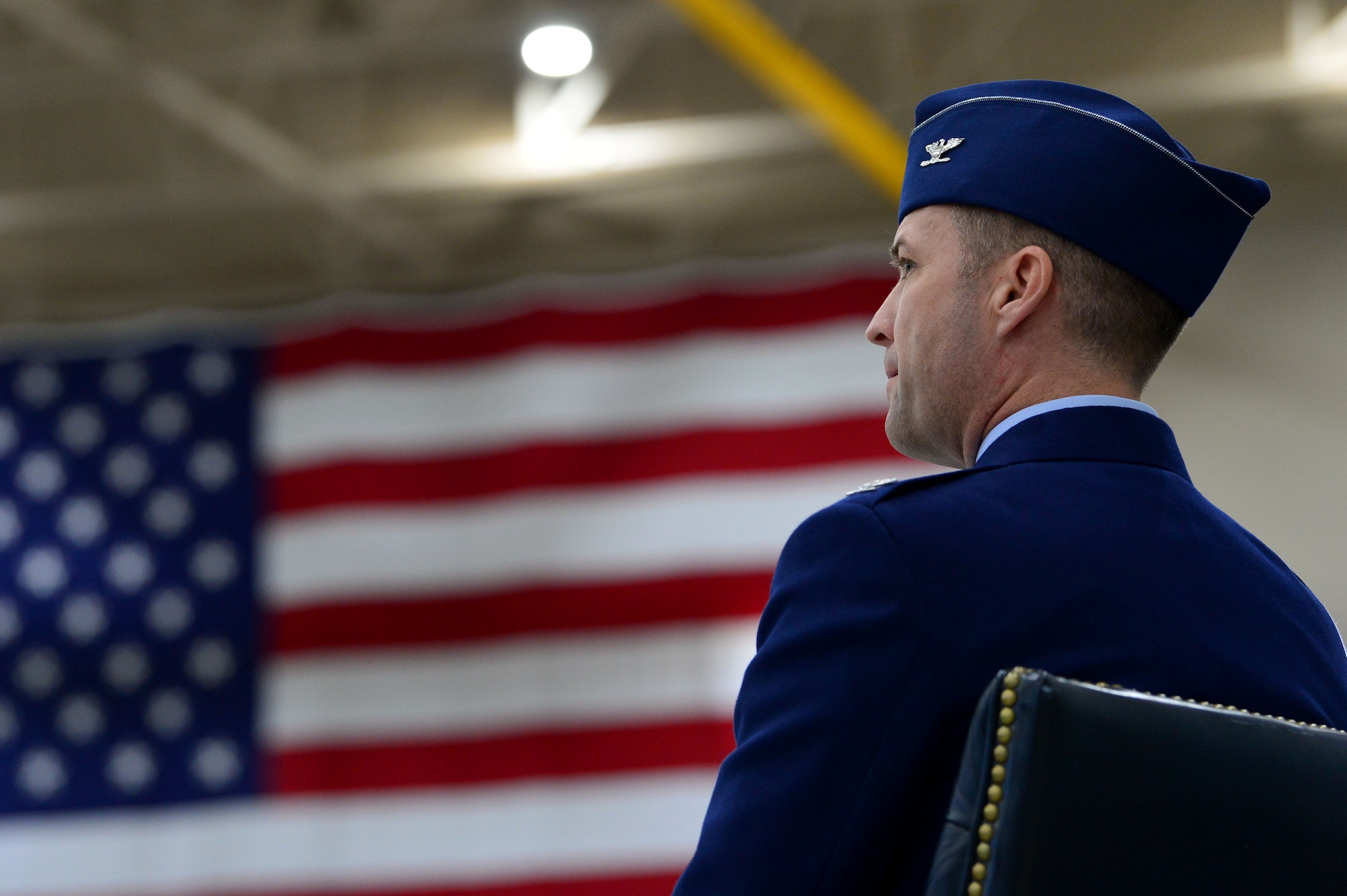 Col. Stephen Jones, incoming 432nd Wing/432nd Air Expeditionary Wing commanders, looks out at the crowd as Maj. Gen. Andrew Croft, Twelfth Air Force (Air Forces Southern) commander, gives opening remarks during the 432nd WG/432nd AEW change of command ceremony at Creech Air Force Base, Nevada, June 7, 2019. Jones has previously been assigned to multiple squadrons at Creech, flown both the MQ-1 Predator and MQ-9 Reaper, and was an initial member of the team that armed the RQ-1 Predator. (U.S. Air Force photo by Airman 1st Class Haley Stevens)