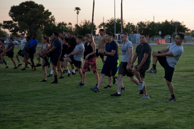 U.S. Marines and Sailors Stationed at Marine Corps Air Station (MCAS) Yuma conduct warm up drills during High Intensity Tactical Training (HITT) on The Lawn at the parade deck on MCAS Yuma Ariz., April 26, 2019. HITT on the Lawn is a physical training event that is open to anyone with base access and provides them with a physical training opportunity. (U.S. Marine Corps photo by Lance Cpl. Joel Soriano)