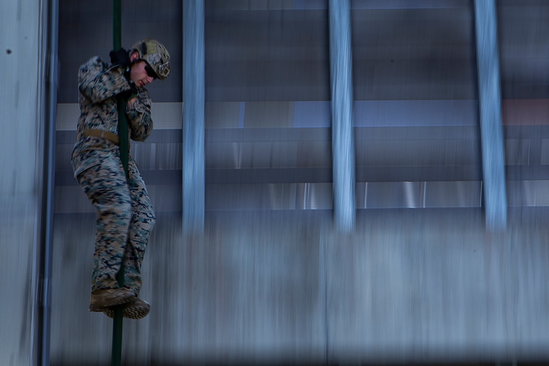 A Marine with Battalion Landing Team, 2nd Battalion, 1st Marines, zips down a line during fast rope training at Camp Schwab, Okinawa, Japan, May 21, 2019. BLT 2/1 is the Ground Combat Element for the 31st Marine Expeditionary Unit. The 31st MEU, the Marine Corps' only continuously forward-deployed MEU partnering with the U.S. Navy's Amphibious Squadron 11, provides a flexible and lethal force ready to perform a wide range of military operations as the premier crisis response force in the Indo-Pacific region. (U.S. Marine Corps photo by Gunnery Sgt. T. T. Parish/Released)