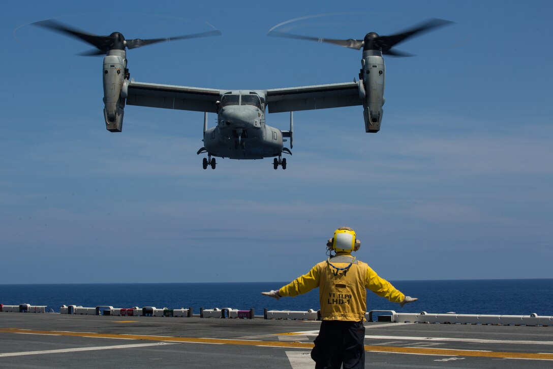 A Sailor guides an MV-22 Osprey tiltrotor aircraft during flight operations aboard the USS Wasp (LHD 1) while underway in the Philippine Sea, June 5, 2019. The 31st MEU, the Marine Corps` only continuously forward-deployed MEU, provides a flexible and lethal force ready to perform a wide range of military operations as the premier crisis response force in the Indo-Pacific region. (Official U.S. Marine Corps photo by Lance Cpl. Kenny Nunez Bigay)