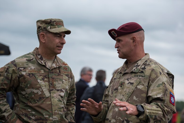 U.S. Air Force Gen. Jeffrey L. Harrigian, United States Air Forces in Europe and Air Forces Africa commander, and Maj. Gen. James J. Mingus, 82nd Airborne Division commander, converse during an intermission in between airborne demonstrations outside Sainte-Mère-Église, France, June 9, 2019. The airborne demonstrations, which featured 900 military paratroopers, commemorated the U.S. - led airborne operation during D-Day, June 6, 1944. Following the airborne demonstrations, Mingus, as guest speaker, spoke during the annual Iron Mike Ceremony honoring the 254 U.S. soldiers who were killed, and the 525 wounded during the Battle for La Fiere Bridgehead from June 6 - 9, 1944. (U.S. Air Force photo by Senior Airman Kristof J. Rixmann)