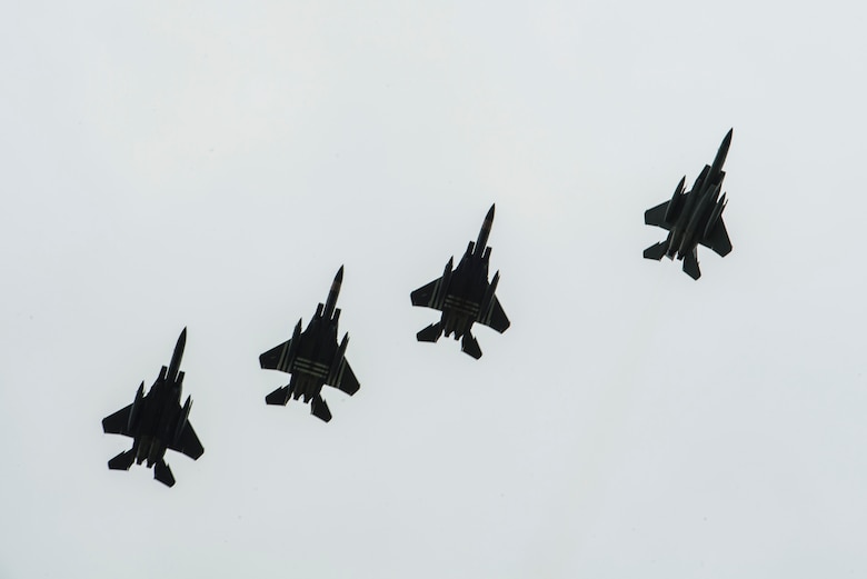 Four F-15E Strikes Eagles, assigned to the 48th Fighter Squadron, Royal Air Force Lakenheath, England,conduct a fighter escort for 23 aircraft dropping personnel into Iron Mike Drop Zone, outside of Saint-Mere-Eglise, France June 9, 2019. The F-15s were painted in honor of their predecessor aircraft, the P-47s Thunderbolts from World War II. (U.S. Air Force photo by Senior Airman Devin M. Rumbaugh)