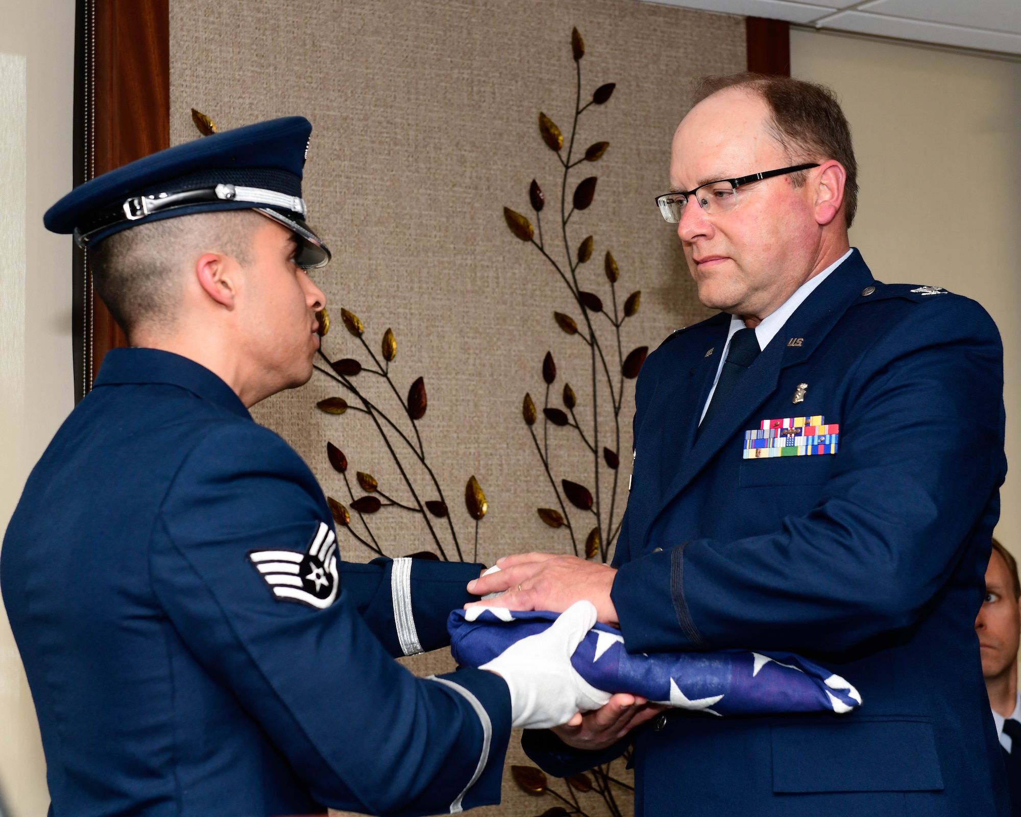 Col. Rodney Waite, the commander of the 910th Medical Squadron, receives an American flag from Staff Sgt. Felipe Henao, a health services manager with 910th MDS, during Waite’s retirement ceremony, May 4, 2019.