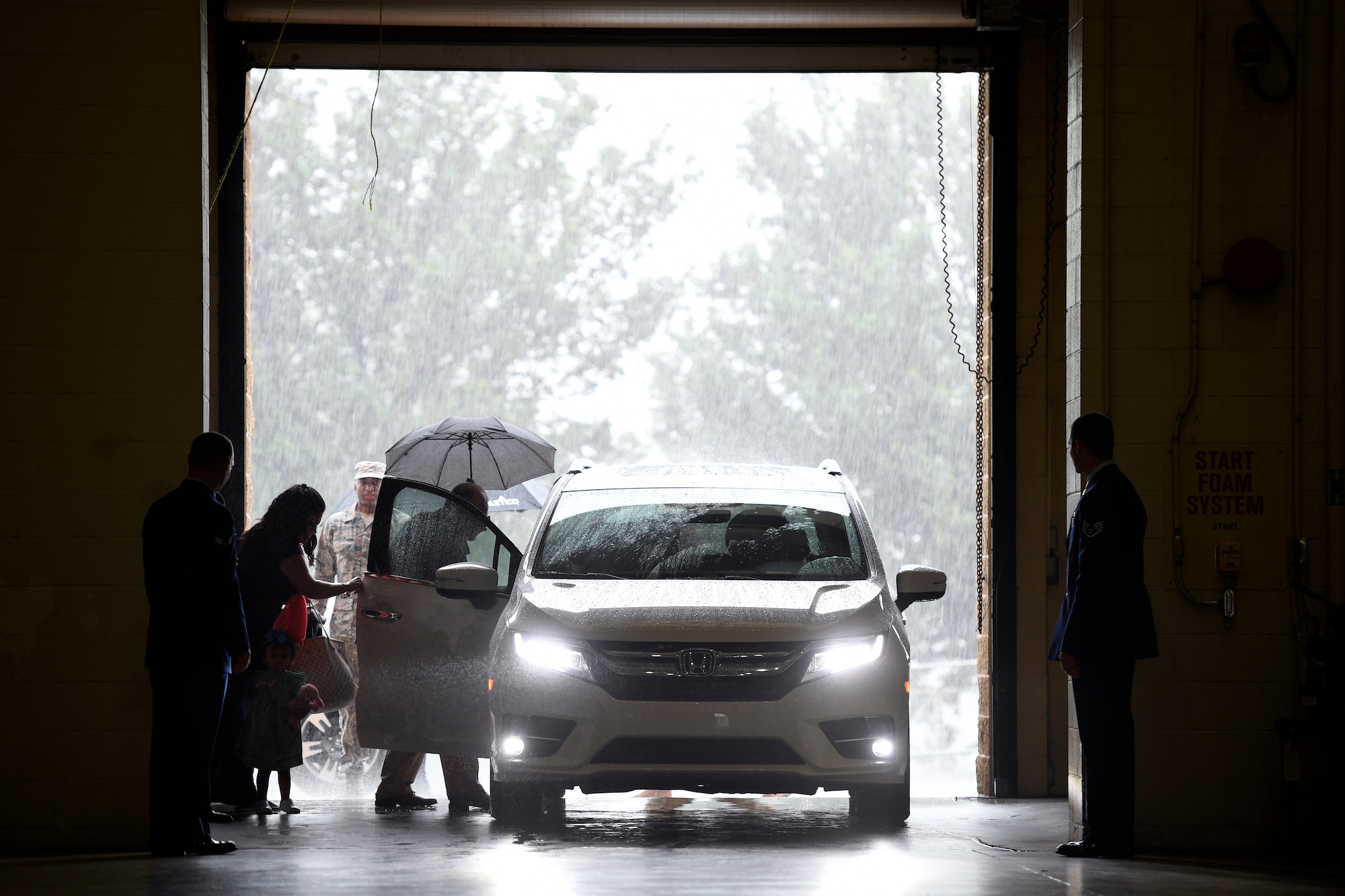 Torrential rain pours down as family members arrive for the Building Dedication Ceremony to honor four fallen Airmen, U.S. Air Force Lt. Col. Paul K. Mikeal, Maj. Joseph M. McCormick, Maj. Ryan S. David, and Senior Master Sgt. Robert S. Cannon, at the North Carolina Air National Guard Base, Charlotte Douglas International Airport, June 9, 2019. The four Airmen tragically lost their lives seven years ago in the Modular Airborne Fire Fighting System (MAFFS) seven accident while fighting fires in South Dakota. These Airmen were part of the MAFFS seven crew and are remembered with building dedication ceremonies to honor their legacy for years to come.