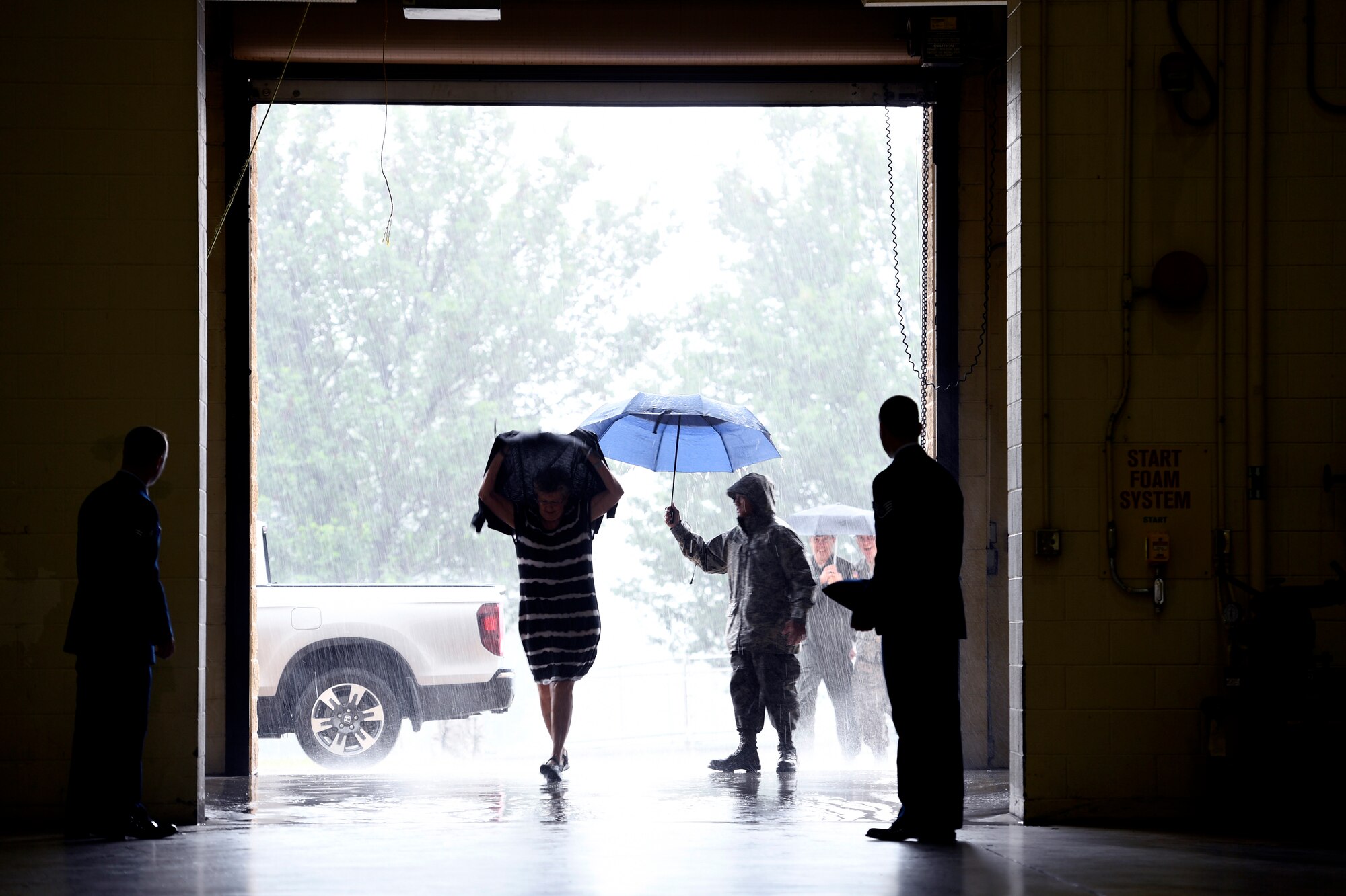 Torrential rain pours down as family members arrive for the Building Dedication Ceremony to honor four fallen Airmen, U.S. Air Force Lt. Col. Paul K. Mikeal, Maj. Joseph M. McCormick, Maj. Ryan S. David, and Senior Master Sgt. Robert S. Cannon, at the North Carolina Air National Guard Base, Charlotte Douglas International Airport, June 9, 2019. The four Airmen tragically lost their lives seven years ago in the Modular Airborne Fire Fighting System (MAFFS) seven accident while fighting fires in South Dakota. These Airmen were part of the MAFFS seven crew and are remembered with building dedication ceremonies to honor their legacy for years to come.