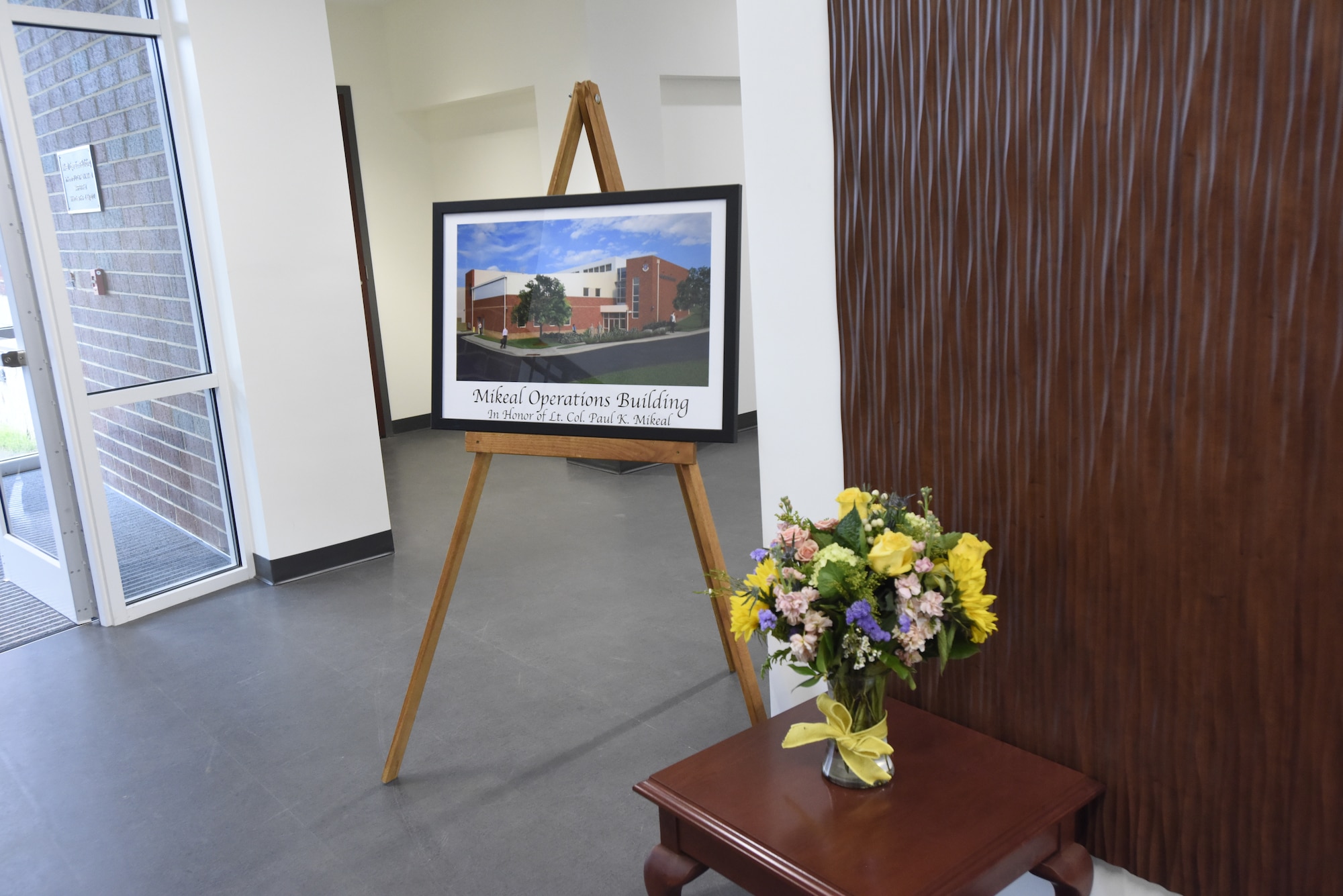 A commemorative picture is displayed during the dedication of the 145th Airlift Wing C-17 operations building to U.S. Air Force Lt. Col. Joseph Mikeal, at the North Carolina Air National Guard Base, Charlotte Douglas International Airport, June 9, 2019. Lt. Col. Mikeal tragically lost his life alongside 3 other C-130 crew members in the MAFFS 7 aircraft accident in 2012, the 145th Airlift Wing honored his and the other crew members sacrifice by naming four buildings across the wing after each one.