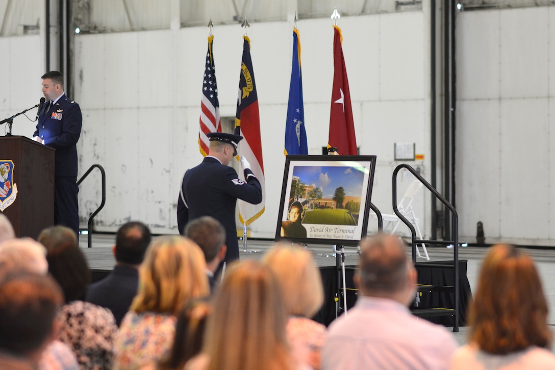 A member of the 145th Airlift Wing Honor Guard renders salute to a commemorative photo designed and printed in honor of U.S. Air Force Maj. Ryan S. David during the 145th Airlift Wing Building Dedication ceremony, at the North Carolina Air National Guard Base, Charlotte Douglas International Airport, June 9, 2019. The 145th Airlift Wing dedicated four buildings across the base to the fallen members of the MAFFS aircrew, including Maj. David, who passed away in 2012 following an accident while fighting a wild fire in South Dakota.