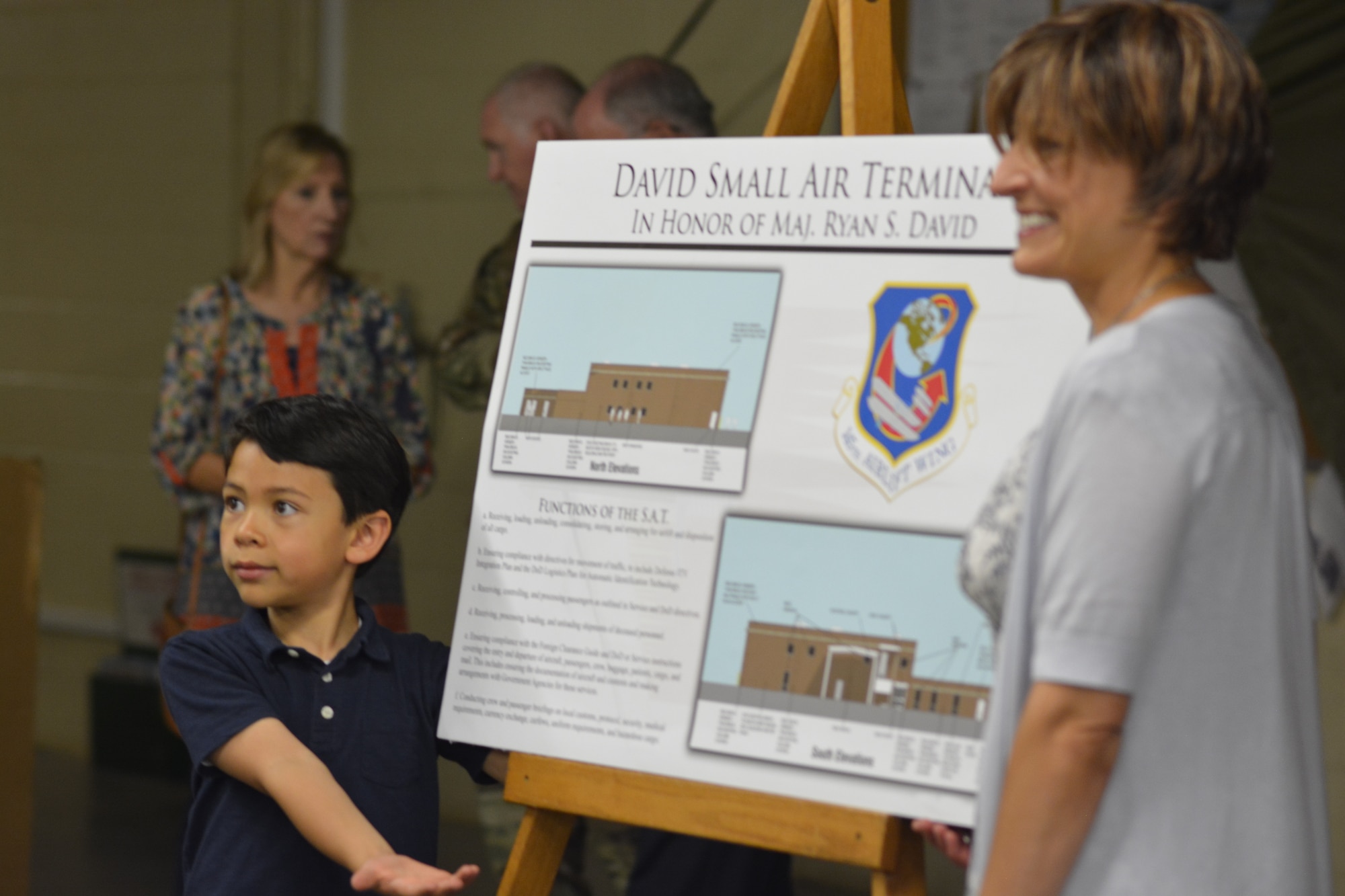 The wife and son of U.S. Air Force Maj. Ryan David show off a display made to explain the function of a Small Air Terminal, following a building dedication ceremony at the North Carolina Air National Guard Base, Charlotte Douglas International Airport, June 9, 2019. The 145th Airlift Wing dedicated four buildings across the base to the fallen members of the MAFFS aircrew, including Maj. David, who passed away in 2012 following an accident while fighting a wild fire in South Dakota.