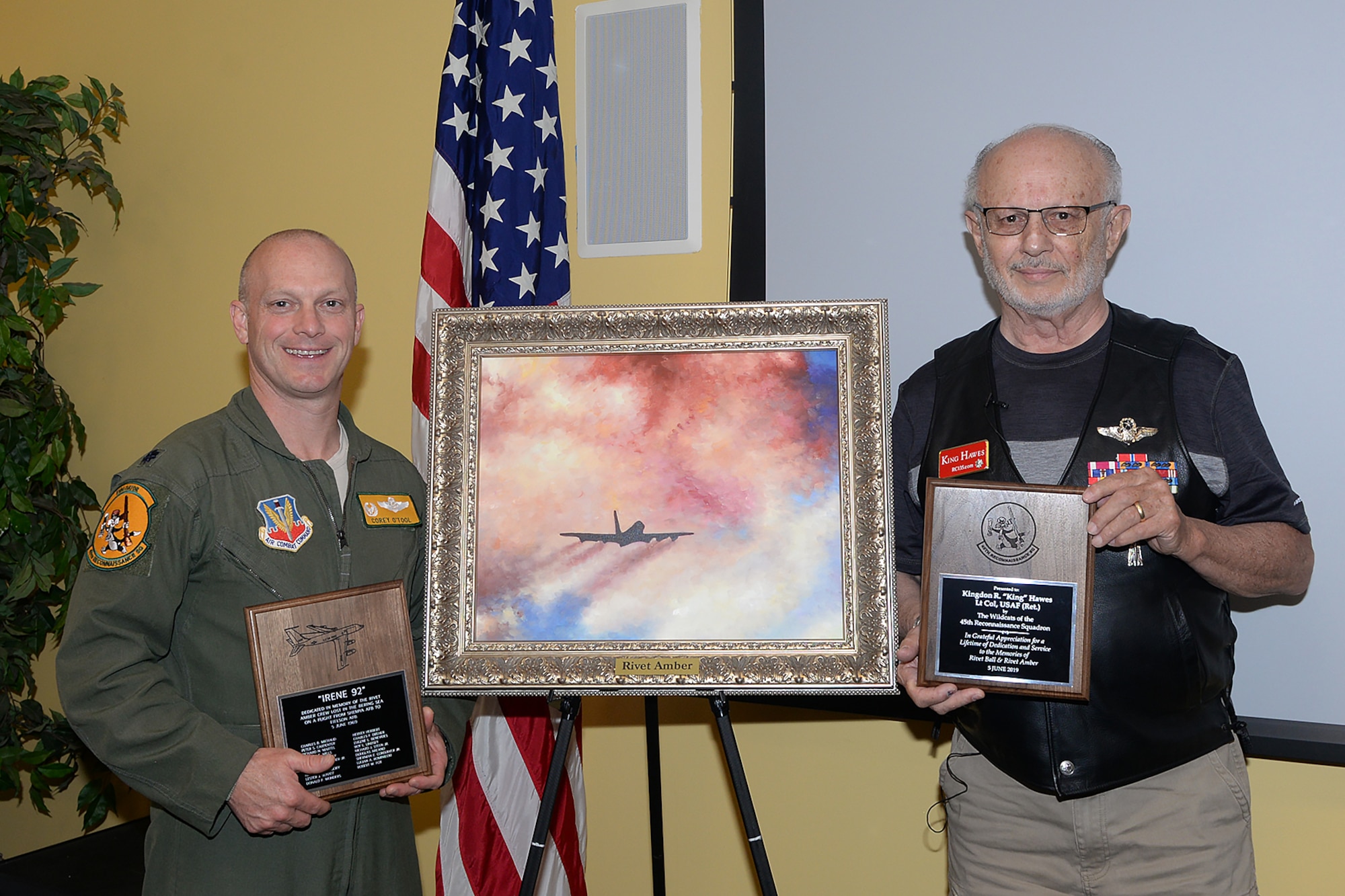 Lt. Col. Corey O'Tool, 45th Reconnaissance Squadron commander and retired Lt. Col. Kingdon Hawes, acting 45th RS squadron commander the day Rivet Amber disappeared, pose in front of a painting of Rivet Amber at Offutt Air Force Base, Neb., June 5, 2019. Rivet Amber was a one of a kind RC-135 outfitted with reconnaissance equipment that disappeared with 19 aircrew members onboard over the Bearing Sea June 5, 1969.