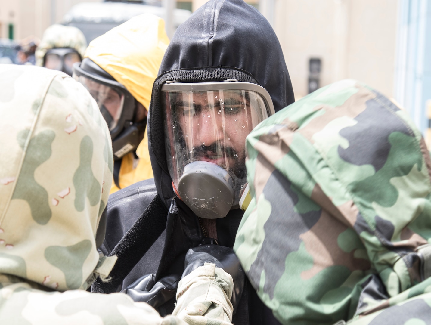 A Kuwaiti chemical, biological, radiological, and nuclear personnel decontaminates his chemical suit before removing it on May 2, 2019 during a joint exercise with a simulated terrorist, explosive ordnance, and chemical situation at the Kuwait Special Forces Training Center. The exercise was crafted to build a shared understanding of Kuwait Civil Authorities and U.S. Forces procedures while reacting to any disaster, natural and manmade alike.